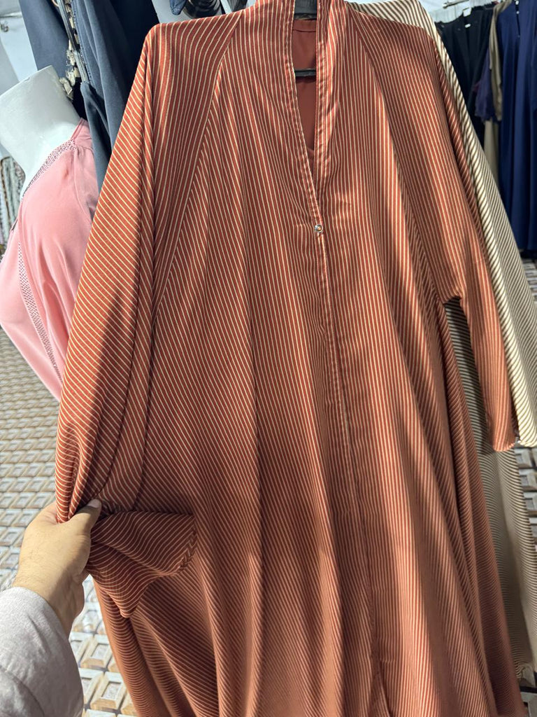 Designer orange striped abaya online featuring white vertical lines  contemporary modest wear