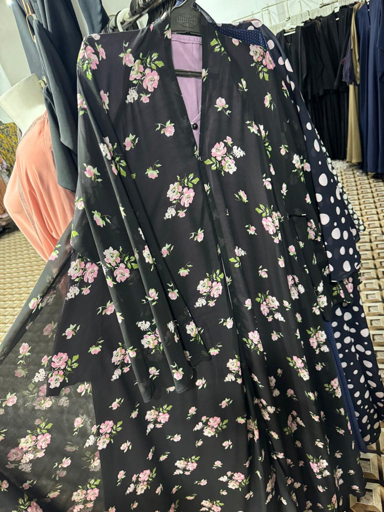 Designer black floral abaya online featuring pink roses and white flowers  contemporary modest wear